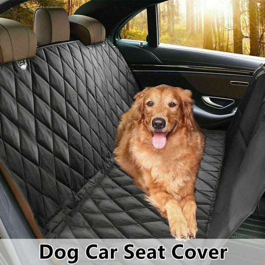 Golden retriever sitting on a black quilted dog car seat cover in the back of a car